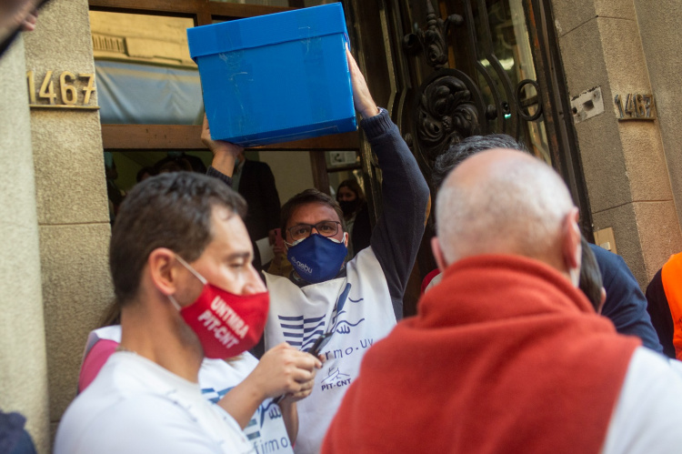 Juan Fernández, de la comisión prorreferéndum de AEBU, porta una caja con firmas a la entrada de la Corte Electoral | Foto: Alessandro Maradei.